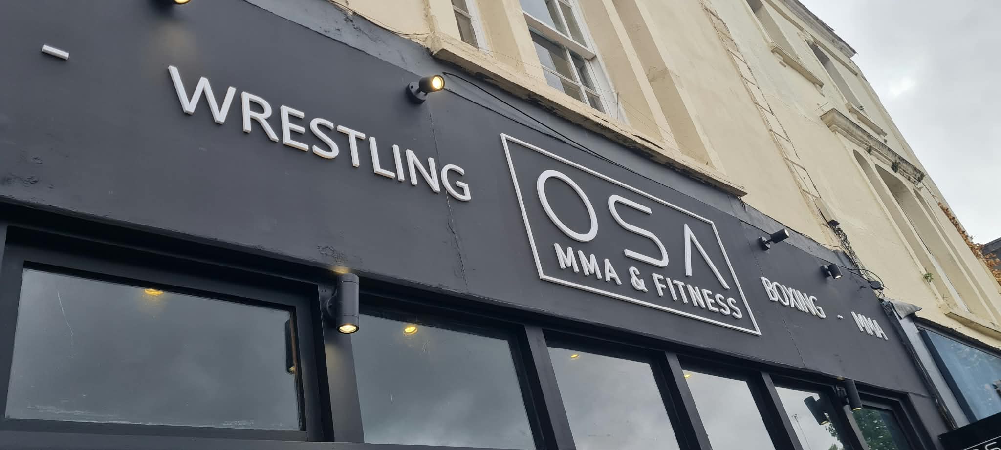 Raised white lettering shop fascia sign for OSA MMA & Fitness reading Wrestling, Boxing and MMA on dark grey fascia, Bristol, by Deco Studio